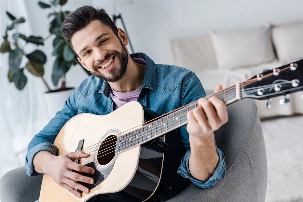 Smiling man, playing guitar